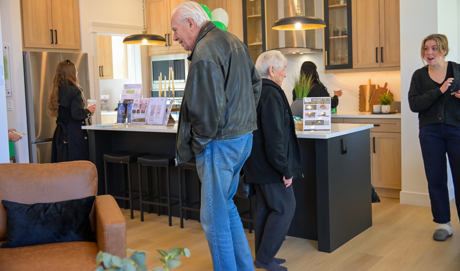Visitors looking over the kitchen in the Aspen Living showhome