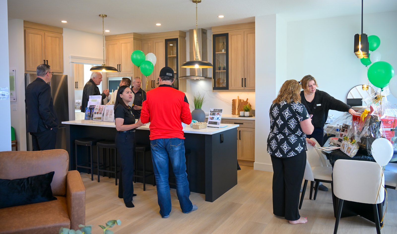 Guests and the Aspen Living team around the kitchen island in the Edgefield showhome on opening day
