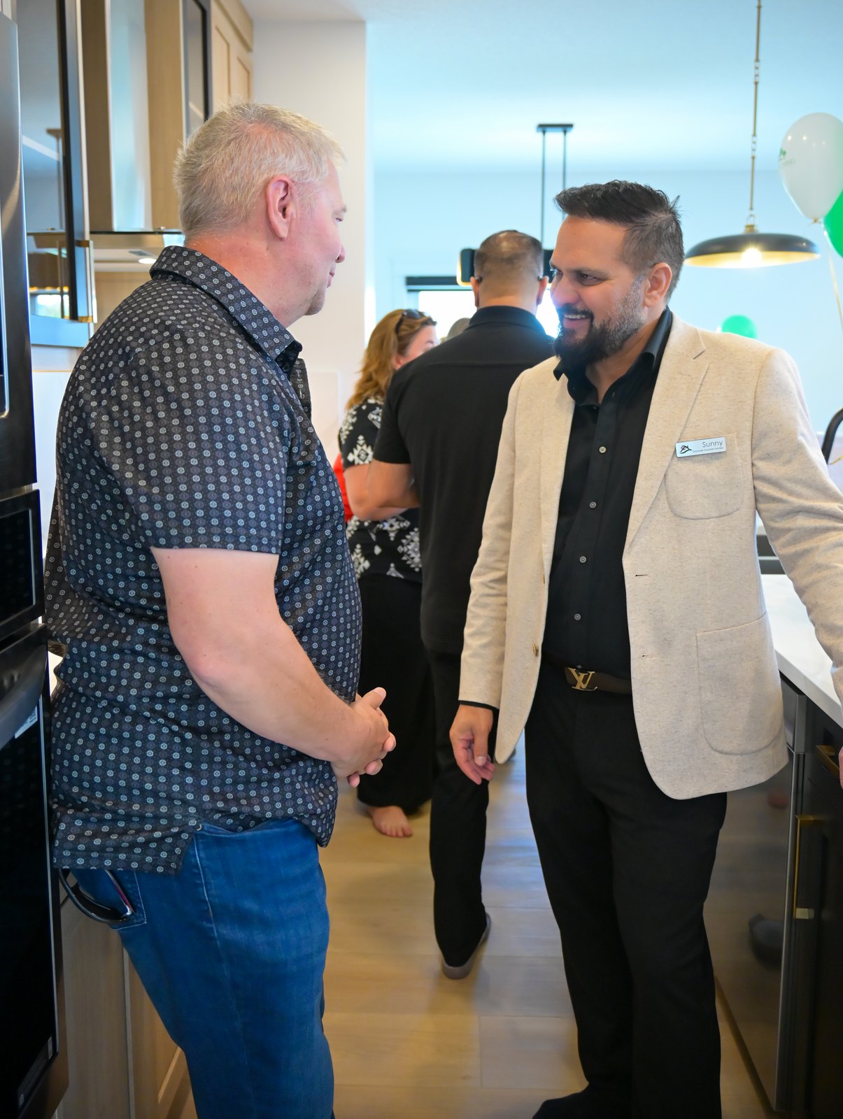 Strathmore Mayor Pat Fule talking with Sunny Sharma of Aspen Living in the showhome kitchen