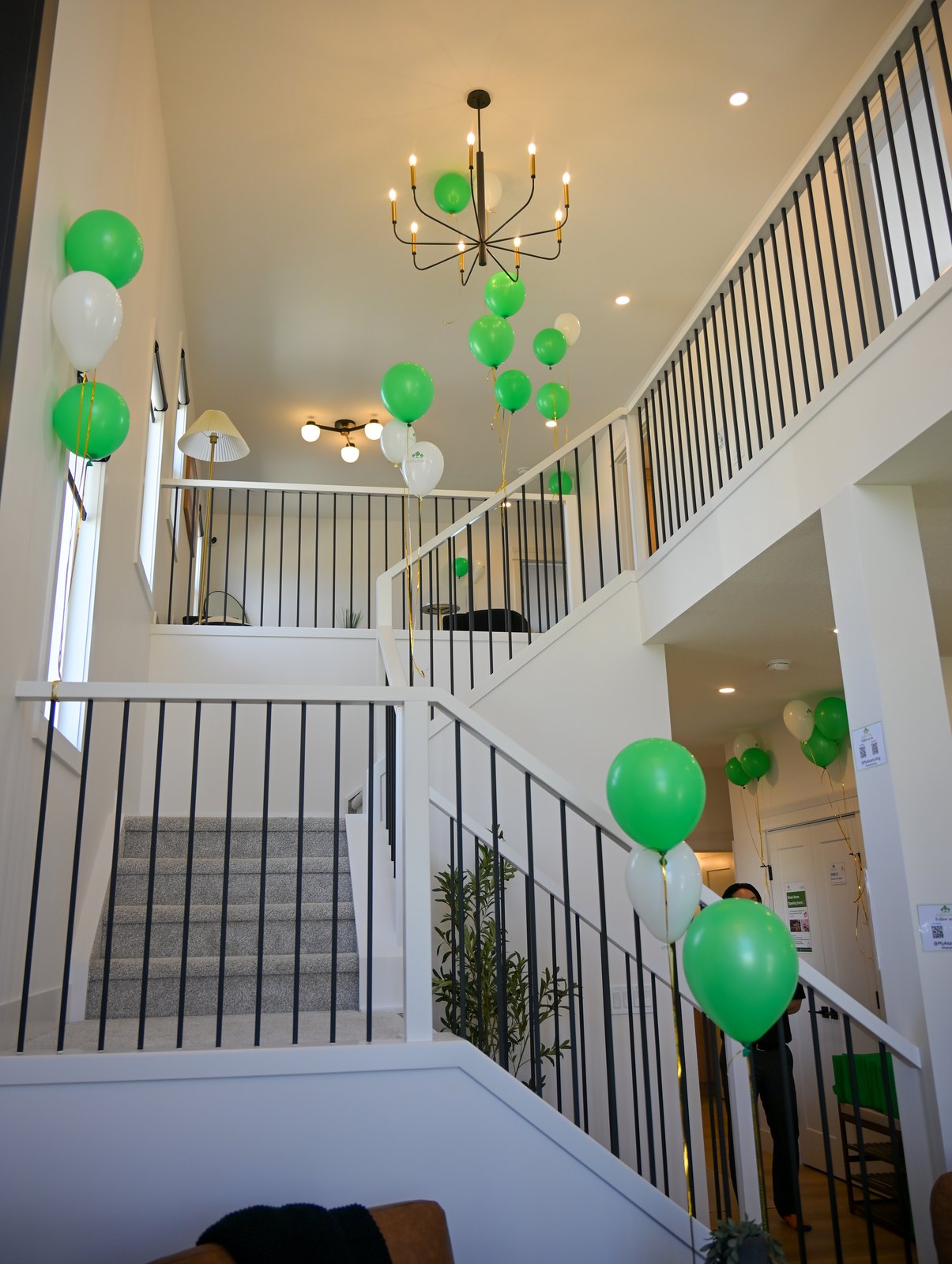 Open-to-below stairwell and chandelier in the Aspen Living showhome