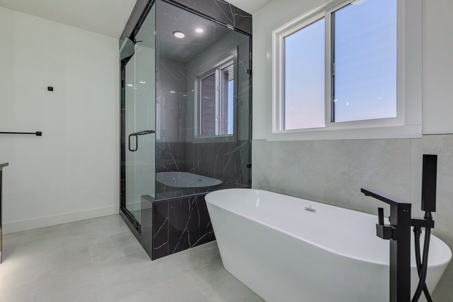 Ensuite with freestanding tub and glass shower in a Waterford Estates home by Aspen Living