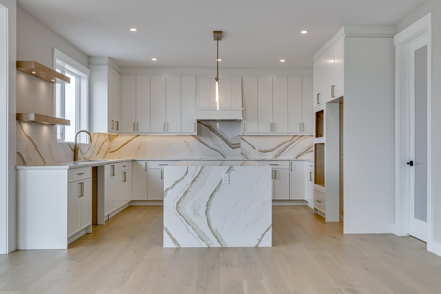 Kitchen with a waterfall quartz island in a Waterford Estates home by Aspen Living