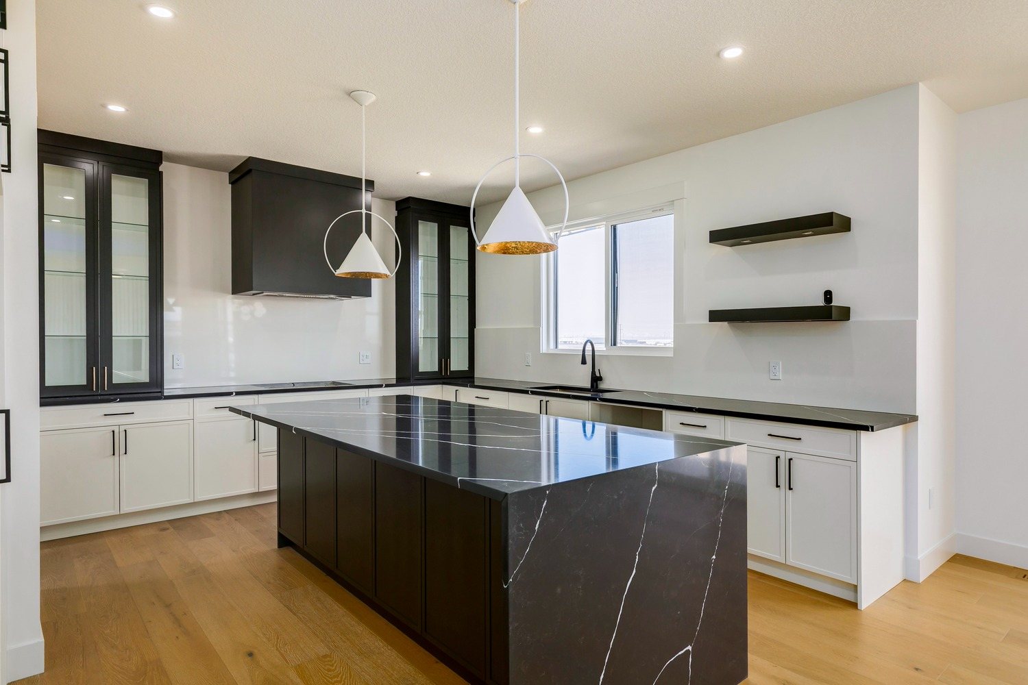 Kitchen with a dark island and open shelving in a Waterford Estates home by Aspen Living