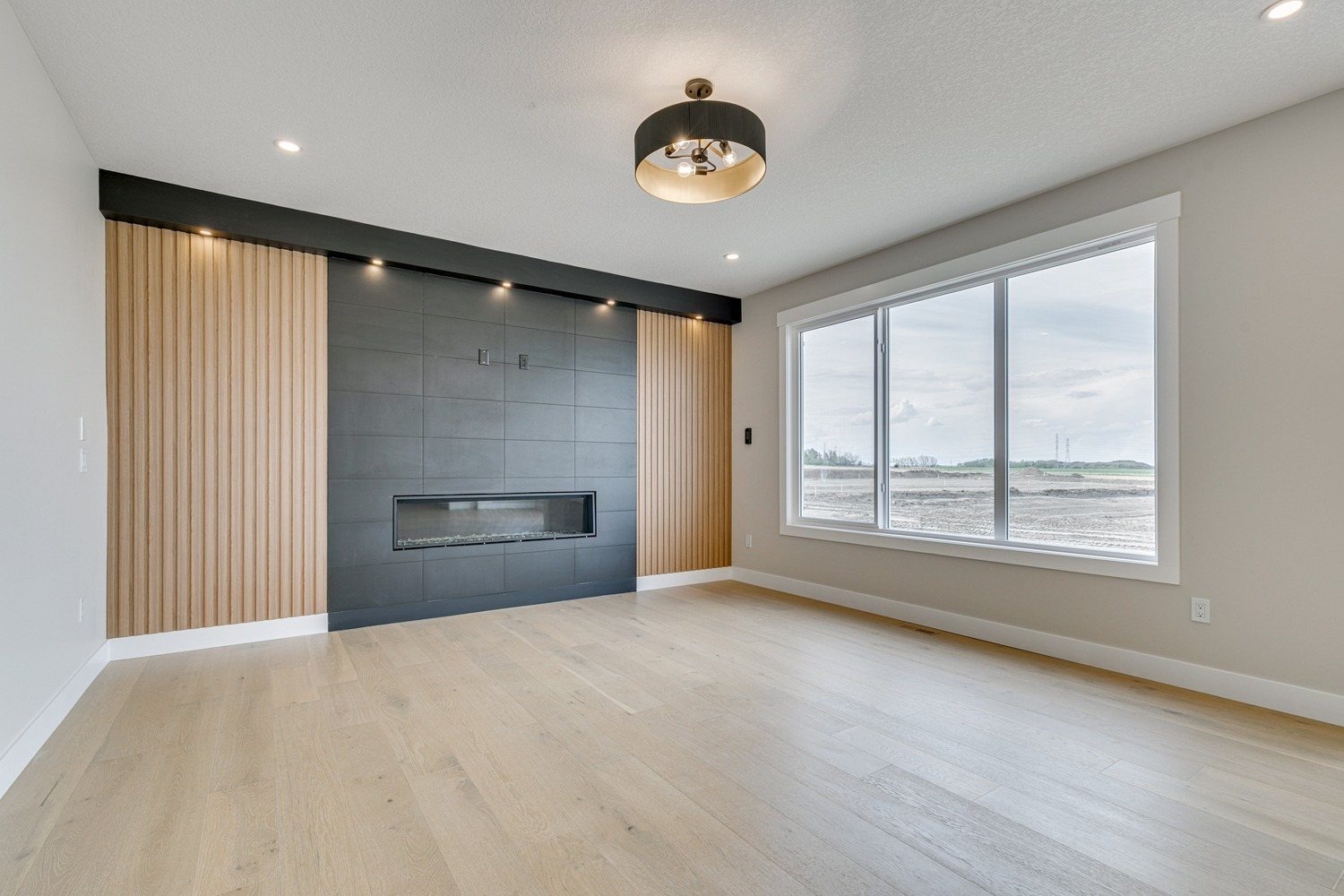 Great room with a tiled linear fireplace in a Waterford Estates home by Aspen Living